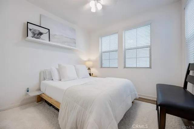 a bedroom with a bed a chair and a window