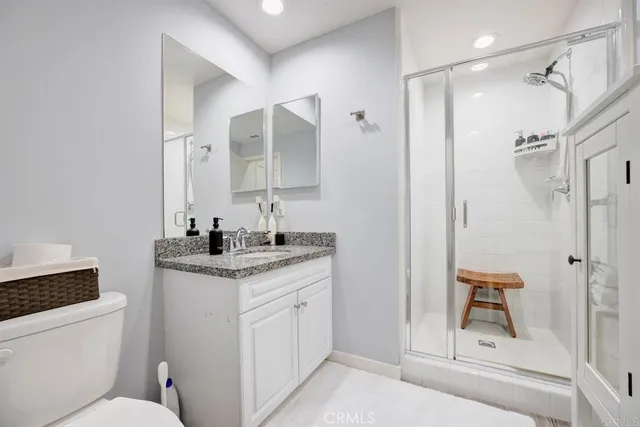 a bathroom with a granite countertop sink toilet and shower