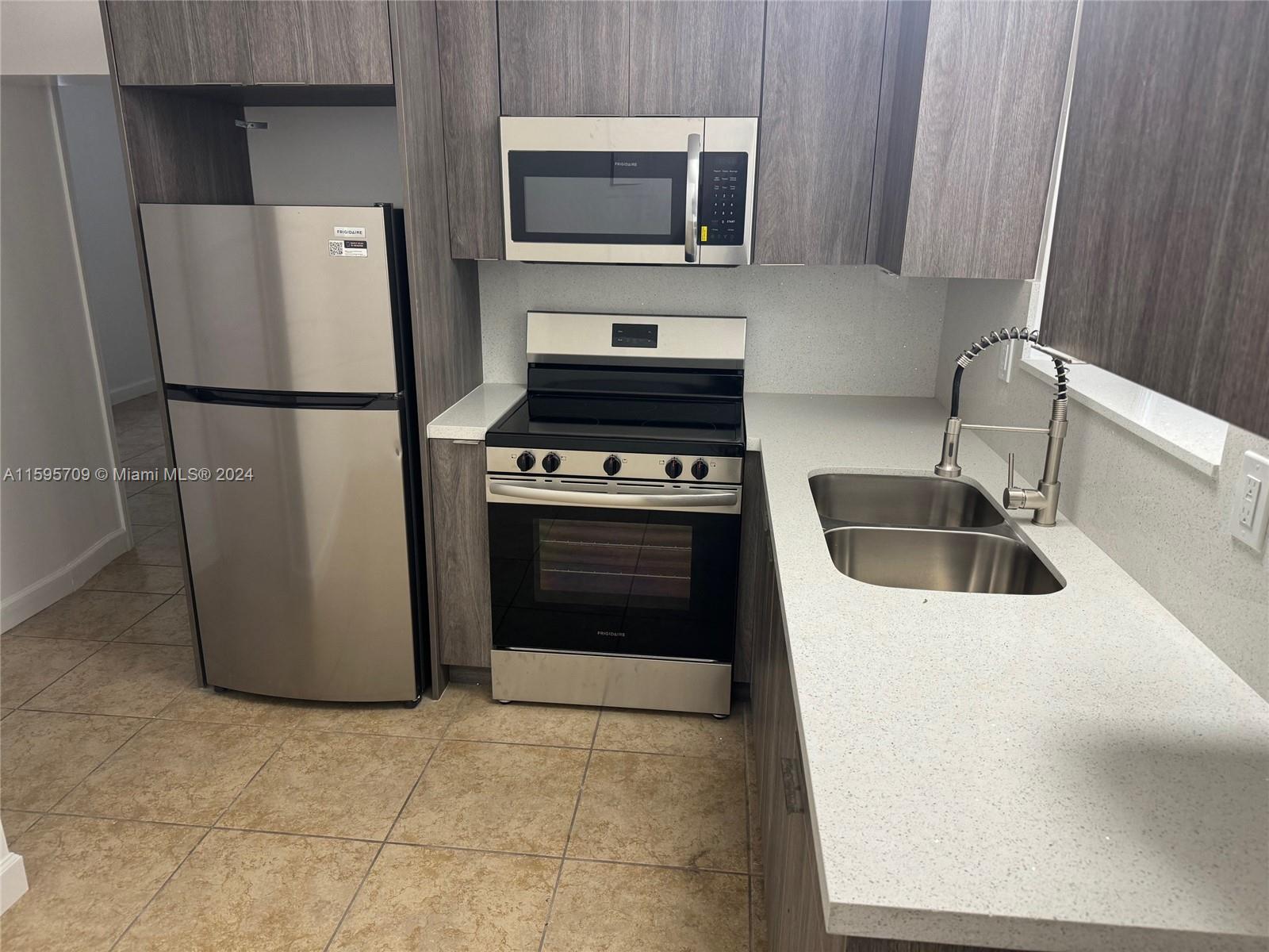 2029 Pierce Street, Unit 3 Hollywood, FL 33020 - Photo 3 of 8 a kitchen with a refrigerator sink and stove