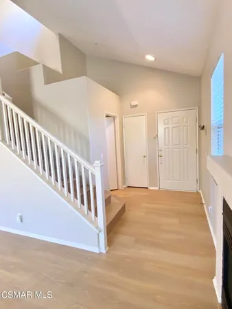 a view of an empty room with stairs and a window