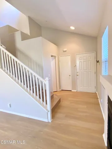 a view of an empty room with stairs and a window