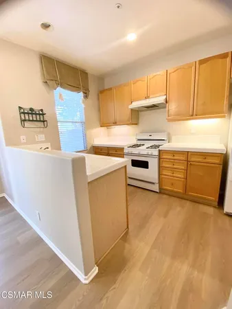 a kitchen with granite countertop a stove top oven sink and cabinets