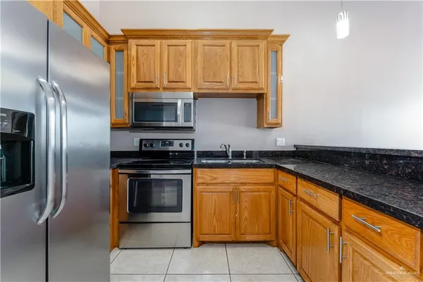 a kitchen with stainless steel appliances granite countertop a refrigerator and a sink