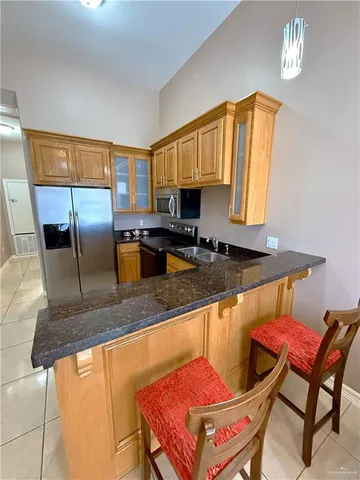 a kitchen with stainless steel appliances granite countertop a sink a stove a table and chairs