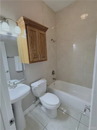 a white toilet sitting next to a bathroom sink and tub
