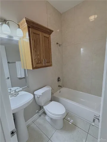 a white toilet sitting next to a bathroom sink and tub