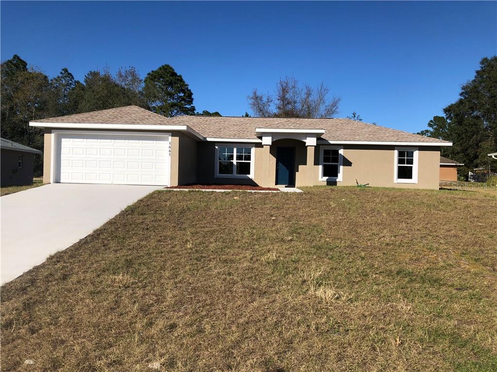 5665 Southwest 129th Place Road Ocala, FL 34473 - Photo 1 of 1 a front view of a house with a yard and garage
