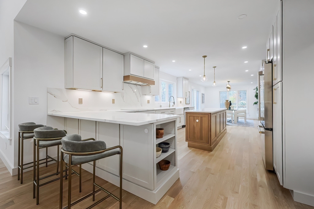 54 Spywood Road Sherborn, MA 01770 - Photo 13 of 41 a kitchen with kitchen island a stove a table and chairs in it