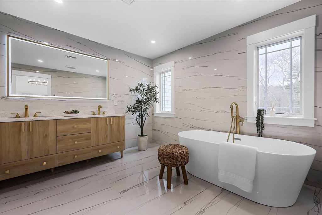 54 Spywood Road Sherborn, MA 01770 - Photo 24 of 41 a bathroom with a double vanity sink a mirror and a bathtub