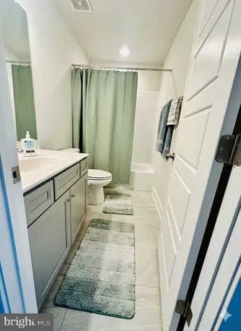 a bathroom with a sink a toilet a mirror and shower