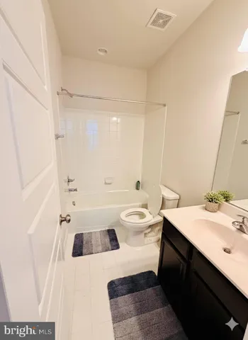 a bathroom with a sink a toilet a mirror and shower