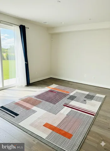 a view of a room with wooden floor and a window