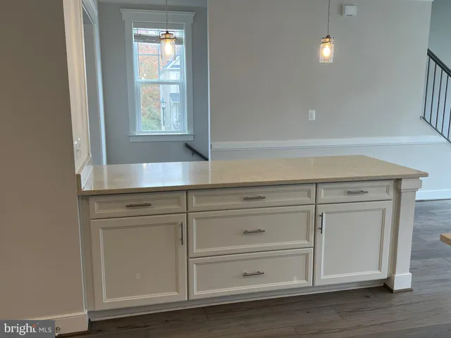 a view white cabinets and wooden floor