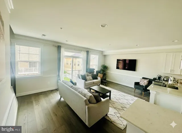 a living room with furniture wooden floor and a large window