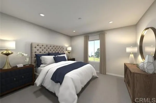 a bedroom with a bed a mirror on dresser and a chandelier