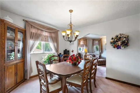 a dining room with furniture a chandelier and window