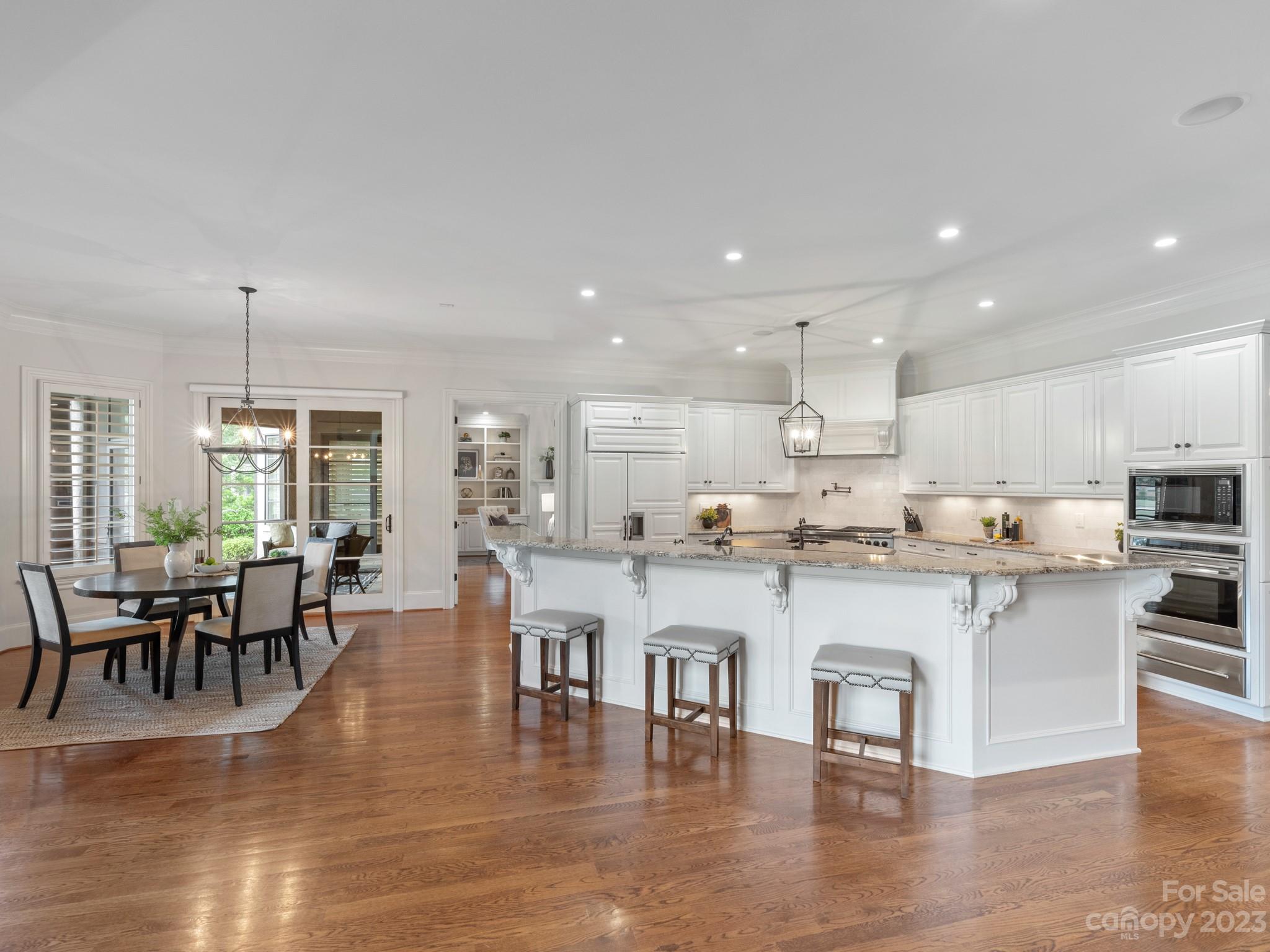 304 Eagle Bend Drive Waxhaw, NC 28173 - Photo 13 of 48 a open kitchen with stainless steel appliances granite countertop a stove top oven a dining table and chairs with wooden floor