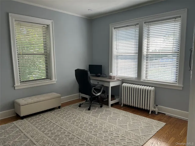 a bedroom with a chair and a window
