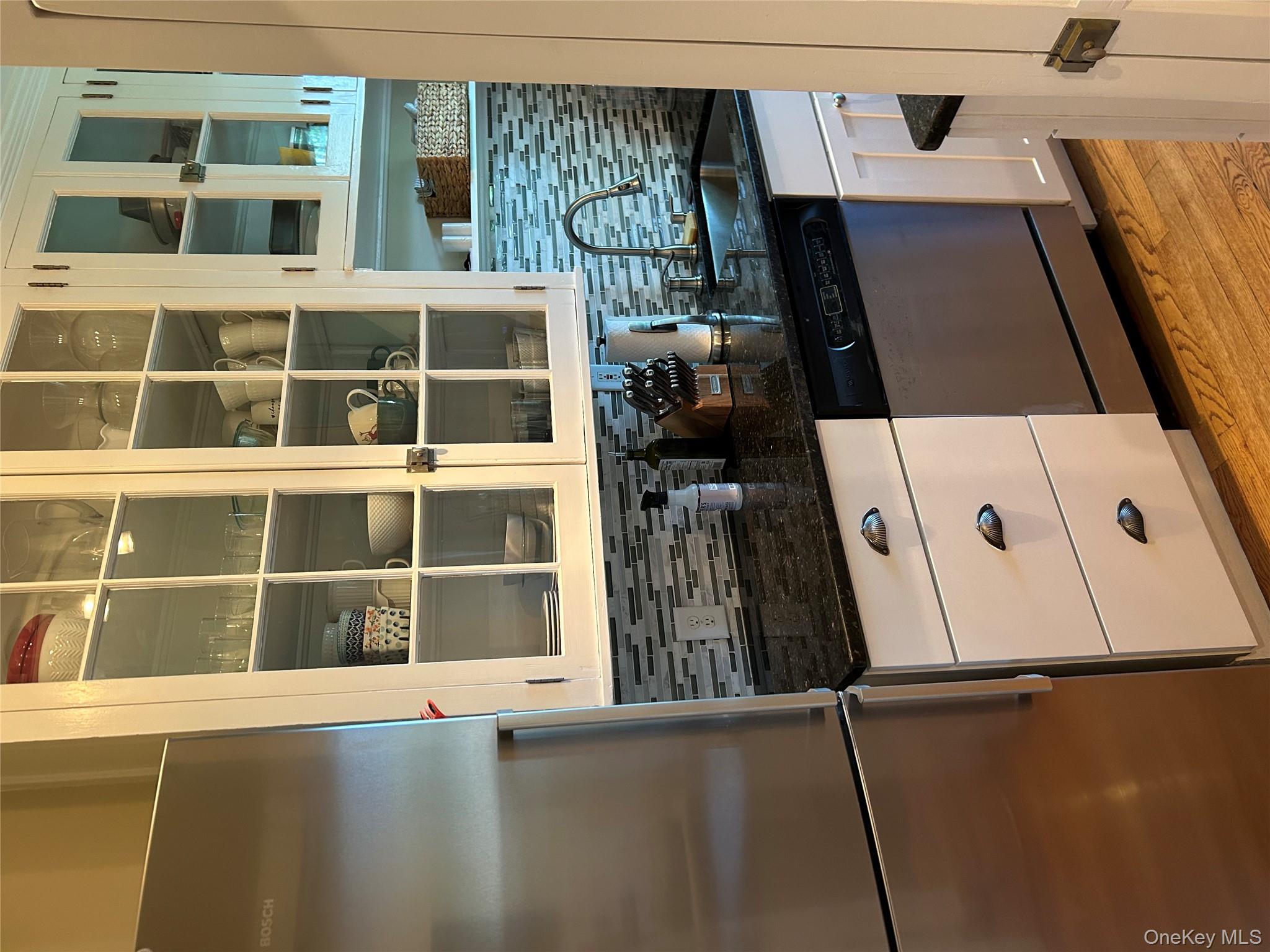 56 Pondfield Road West, Unit 4A Bronxville, NY 10708 - Photo 8 of 22 a kitchen with granite countertop white cabinets and stainless steel appliances