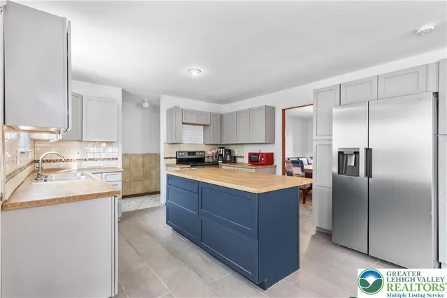 a kitchen with stainless steel appliances granite countertop a stove a sink and a refrigerator