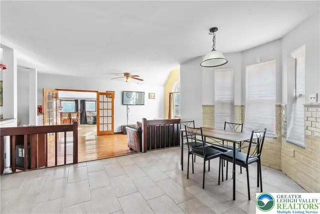 a living room with furniture a large window and wooden floor