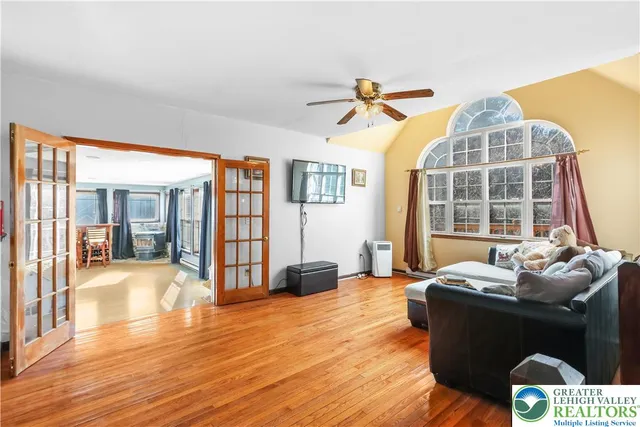 a view of a dining room and livingroom with furniture a chandelier and wooden floor