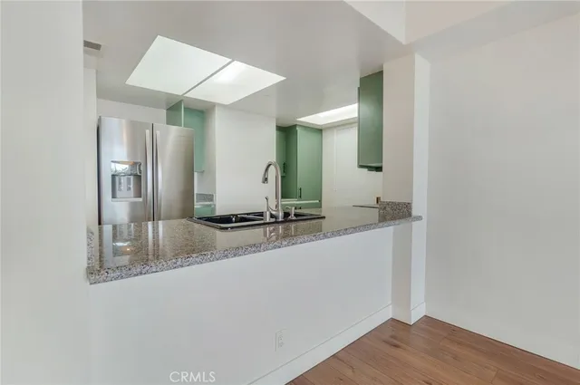 a kitchen with stainless steel appliances granite countertop a sink and a stove top oven