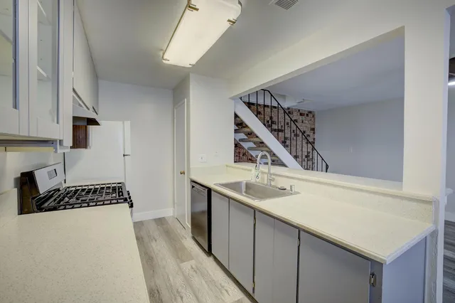 a kitchen with a sink a stove and cabinets