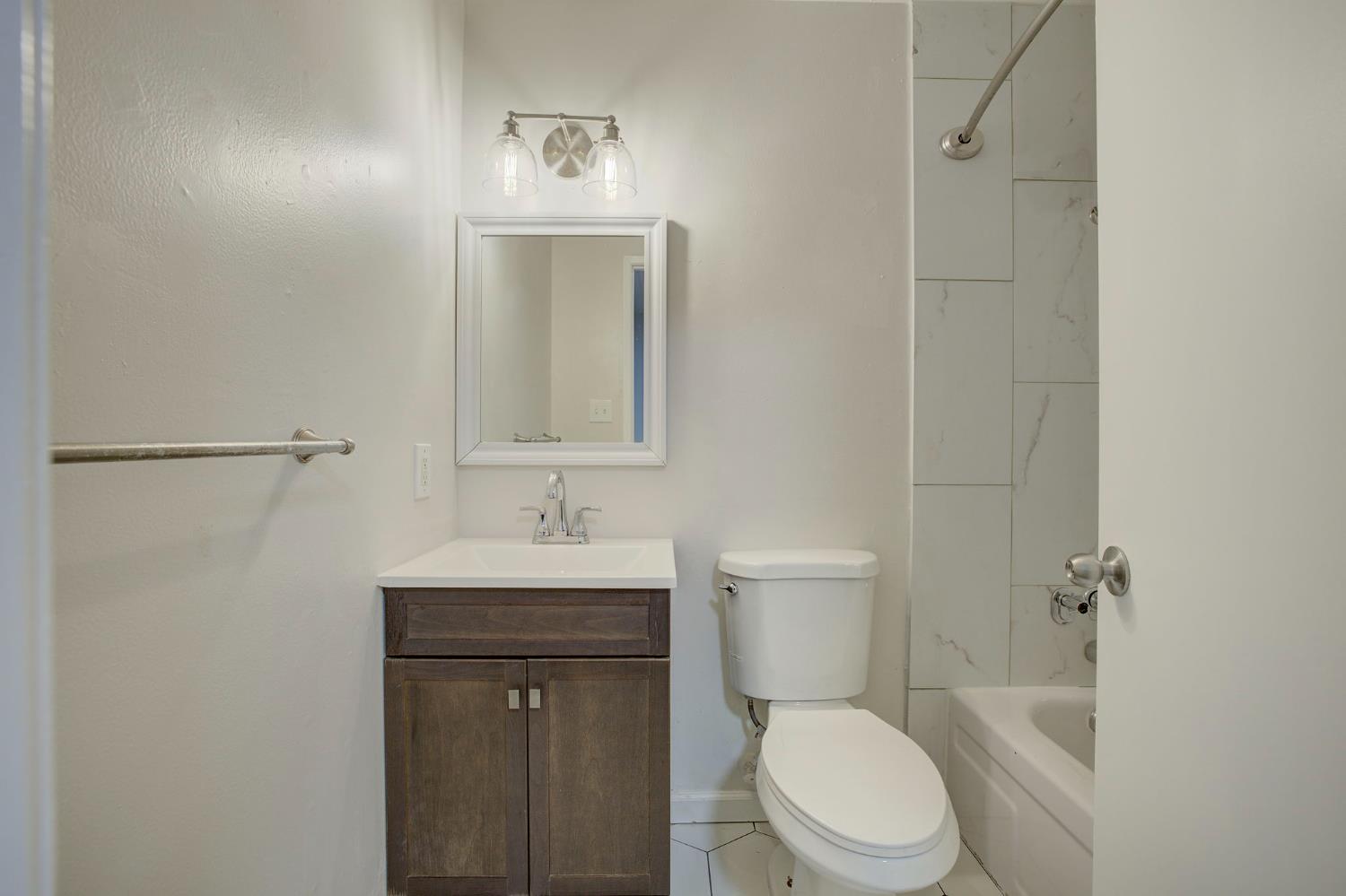 277 Sharp Circle, Unit 2 Roseville, CA 95678 - Photo 15 of 19 a bathroom with a toilet a sink a mirror and vanity