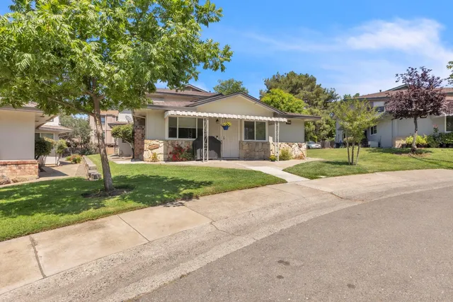 a front view of a house with a yard and potted plants