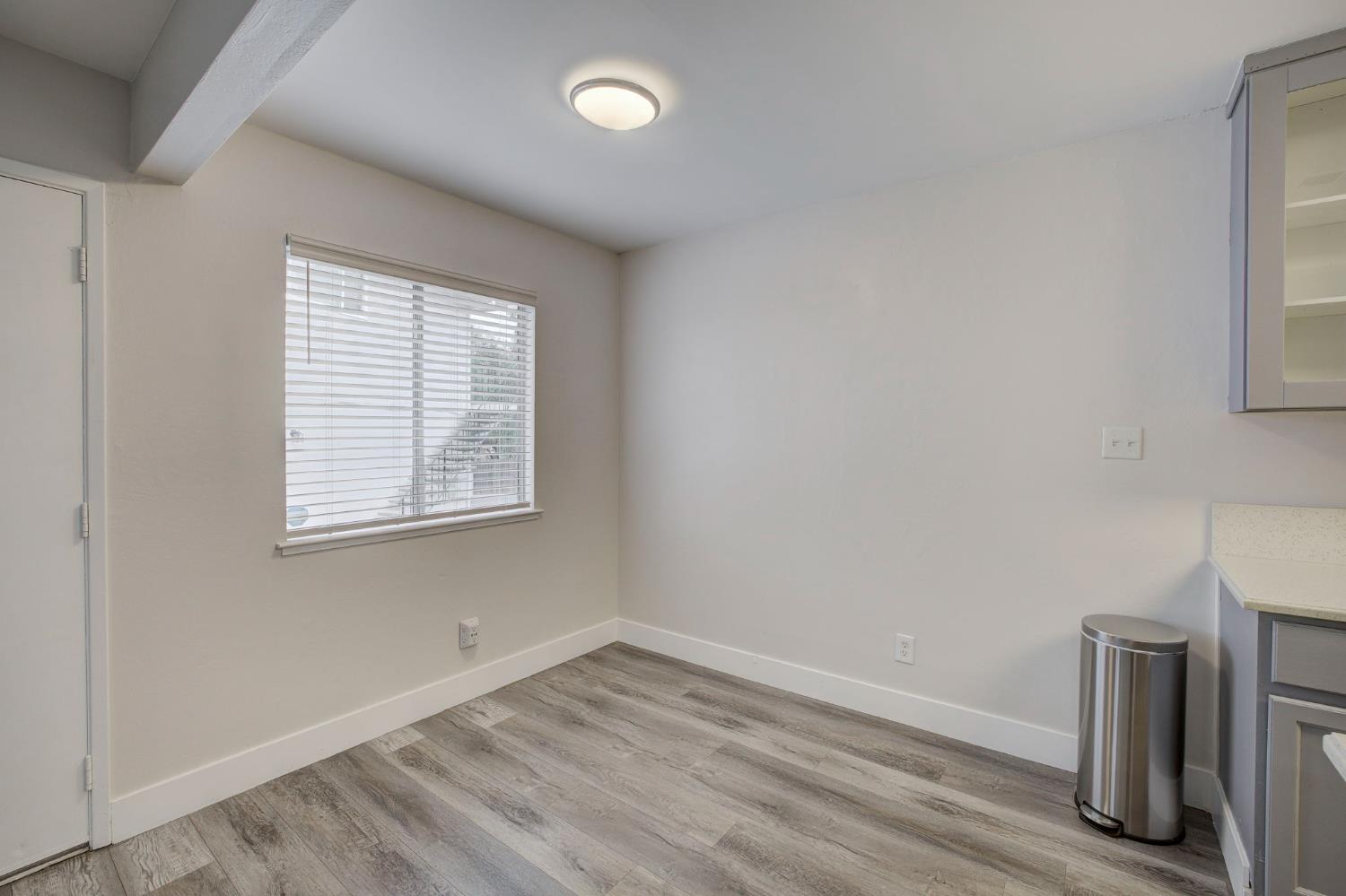 277 Sharp Circle, Unit 2 Roseville, CA 95678 - Photo 8 of 19 an empty room with wooden floor and a window