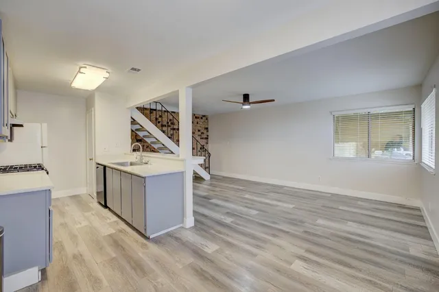 a view of a kitchen with furniture and wooden floor