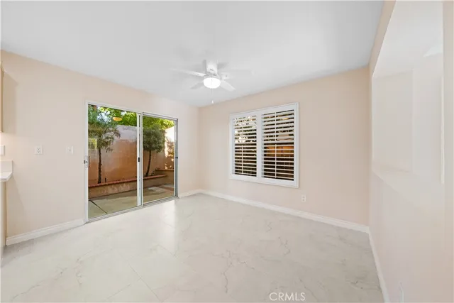 a view of an empty room with glass door and a window