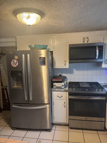 a kitchen with stainless steel appliances granite countertop a stove a refrigerator and a microwave