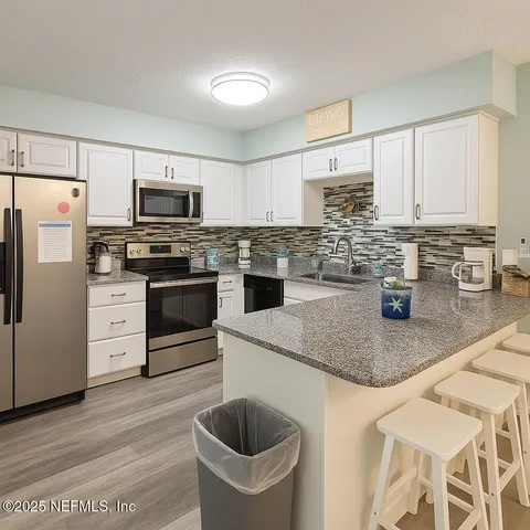 a kitchen with stainless steel appliances granite countertop a sink stove and cabinets