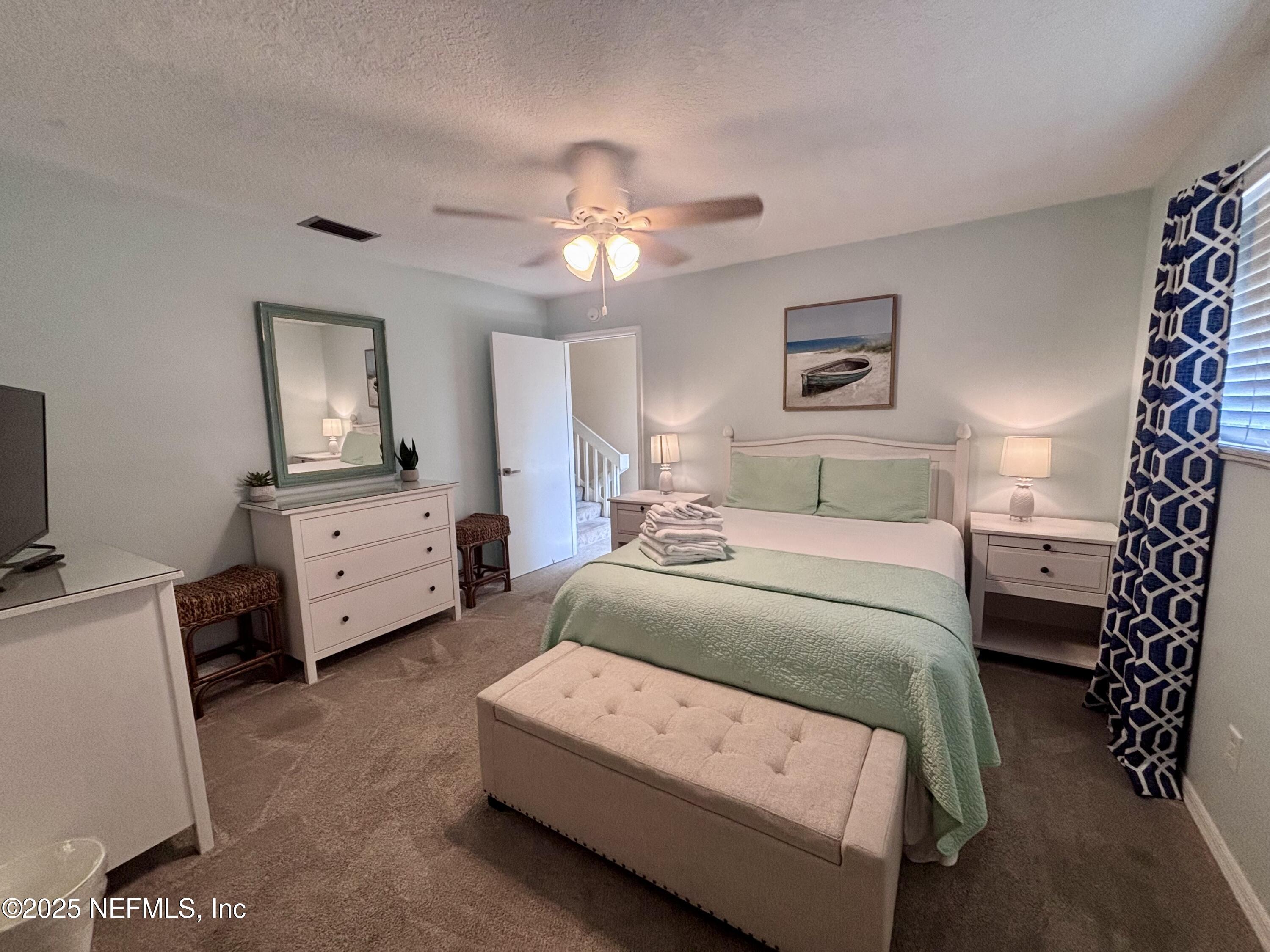 3165 1st Avenue, Unit 13 Fernandina Beach, FL 32034 - Photo 17 of 37 a bedroom with a bed and a chandelier