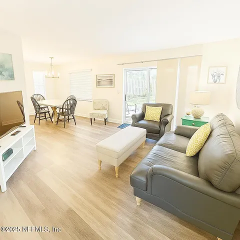 a dining room with wooden floor a chandelier a wooden table and chairs