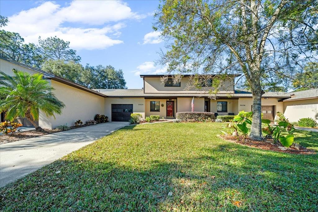 a front view of house with yard and trees around