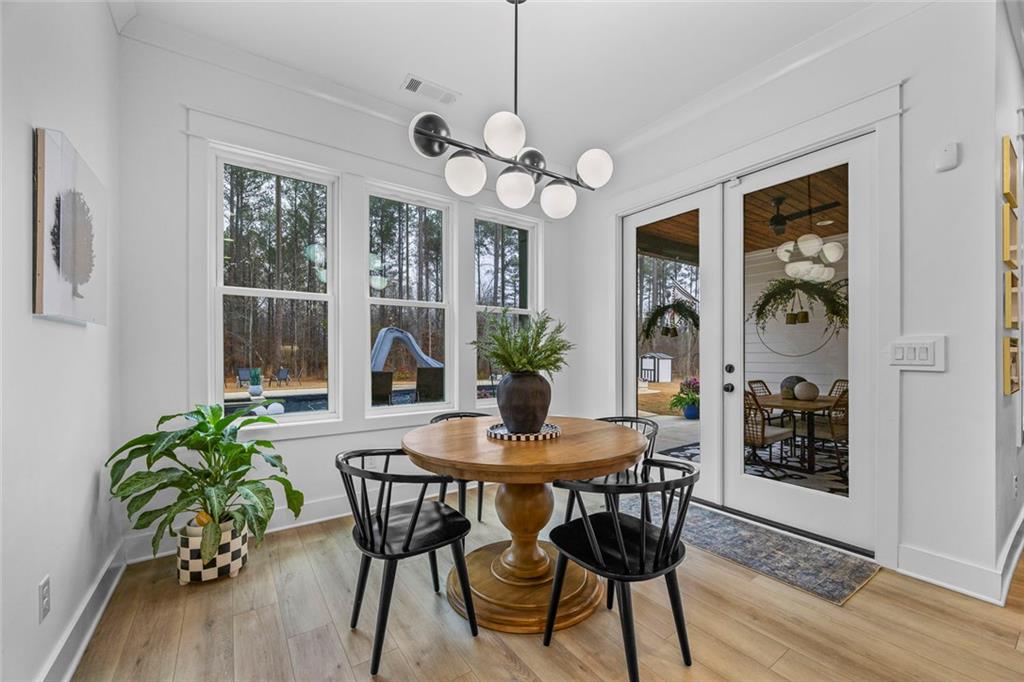 1159 Locklin Road Monroe, GA 30655 - Photo 12 of 63 a dining room with furniture potted plants and wooden floor