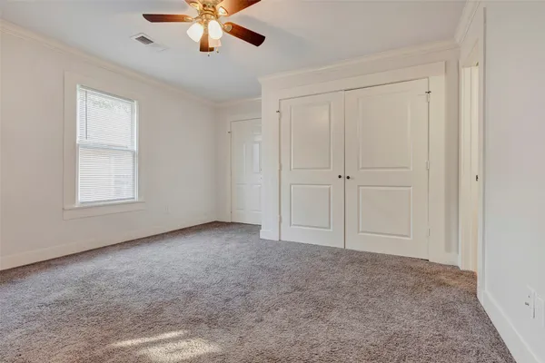 an empty room with chandelier fan