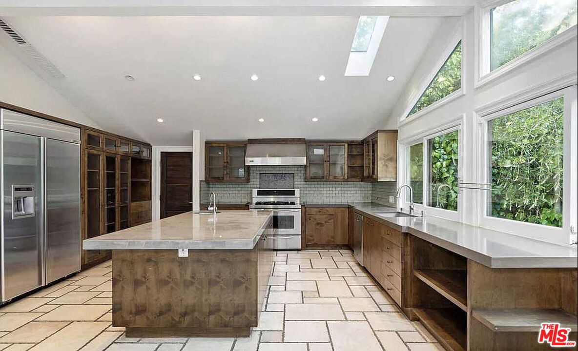 3441 White Rose Way Encino, CA 91436 - Photo 11 of 22 a large kitchen with stainless steel appliances kitchen island granite countertop a large counter top and stove