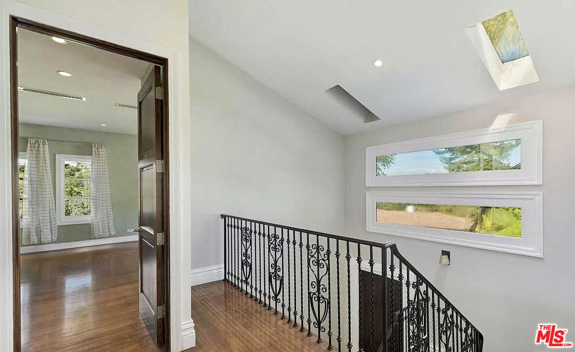 3441 White Rose Way Encino, CA 91436 - Photo 13 of 22 a view of hallway with wooden floor and windows