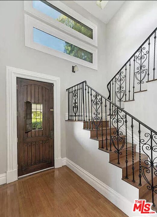 3441 White Rose Way Encino, CA 91436 - Photo 2 of 22 a view of staircase with lots of frames on wall and wooden floor
