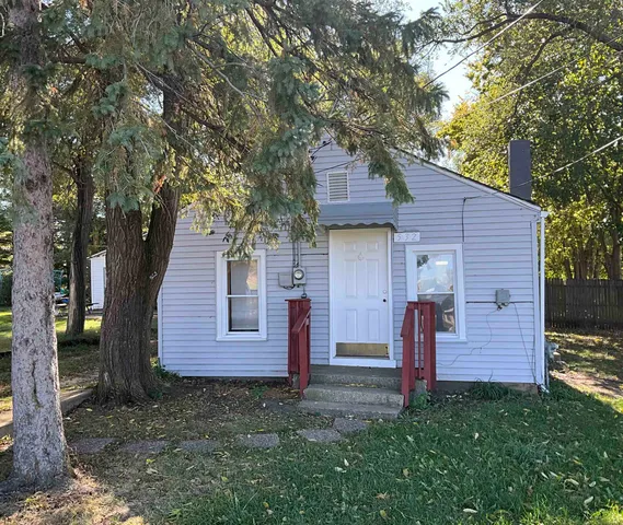 a view of a house with a yard and large tree