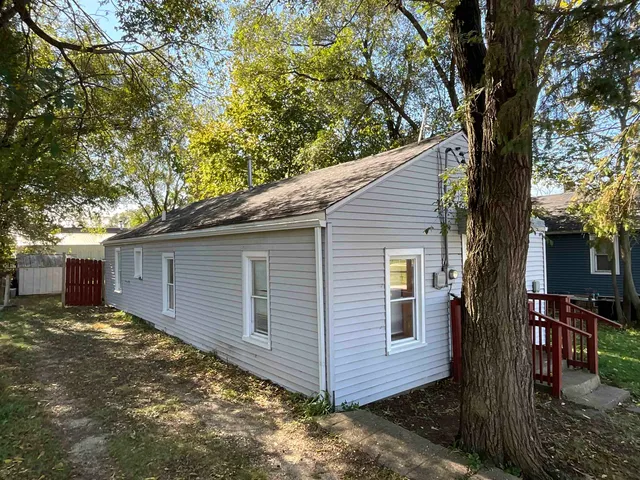 a view of a house with a yard and large tree