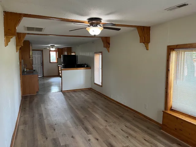 a view of a hallway view with wooden floor and chandelier