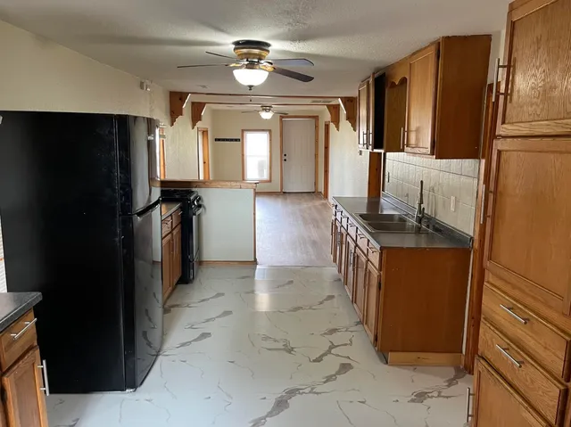 a kitchen with granite countertop a refrigerator a stove and a sink