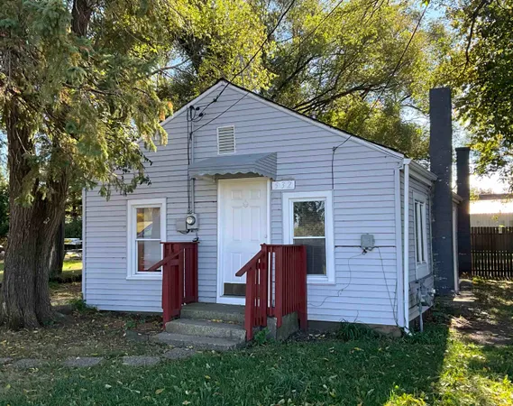 a view of a house with a yard and large tree