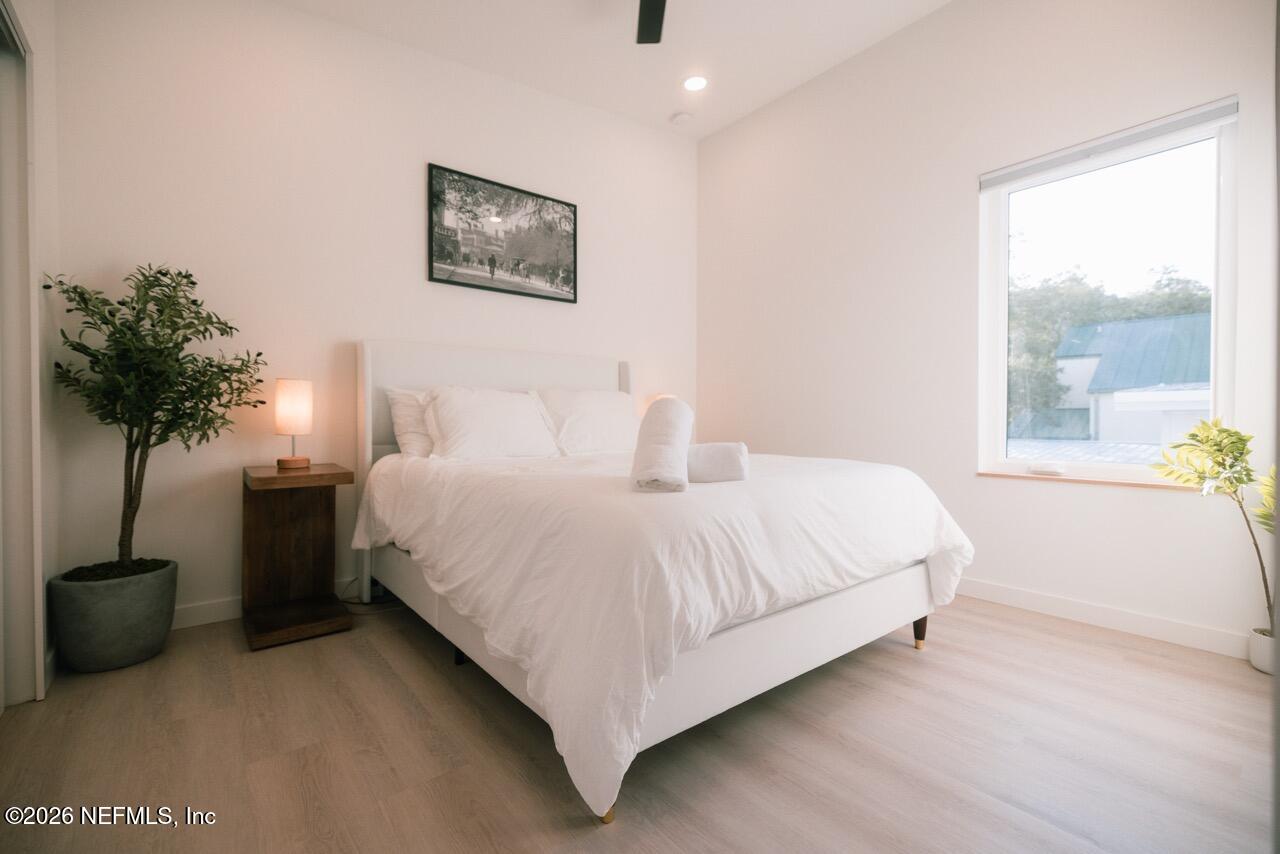 3318 Lewis Speedway St. Augustine, FL 32084 - Photo 14 of 23 a bedroom with a bed and a potted plant