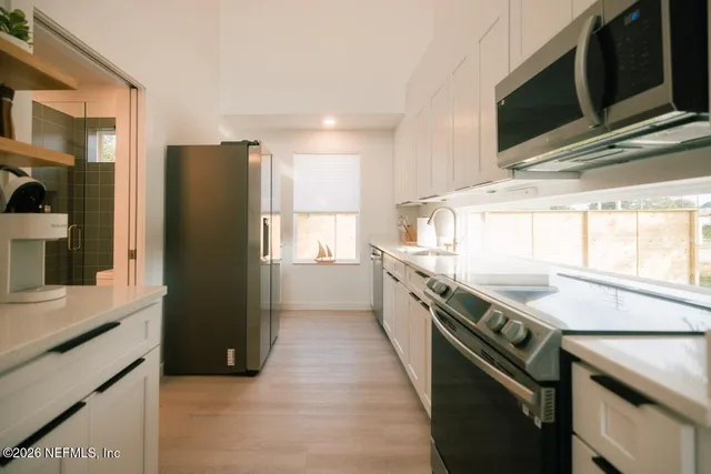 a kitchen with a sink a refrigerator and cabinets